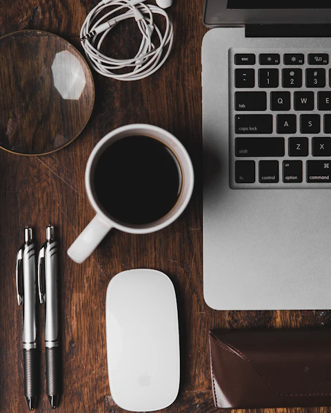 Desk with a notebook, coffee and laptop